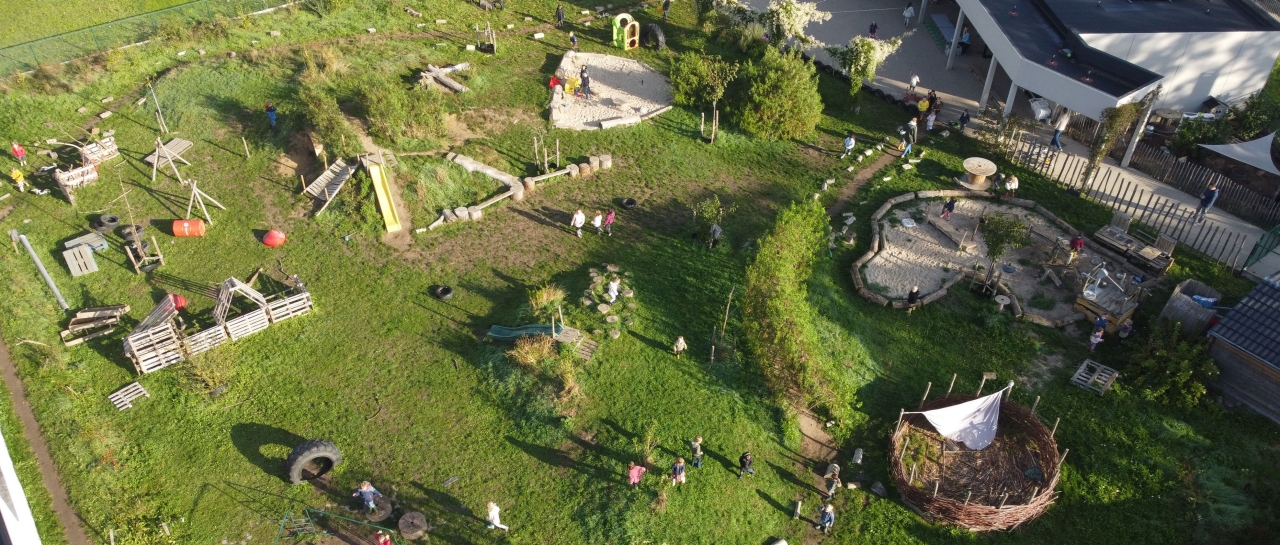 dronebeeld in de lucht getrokken van de klimaatgezonde speelplaats van de Klimop in wetteren