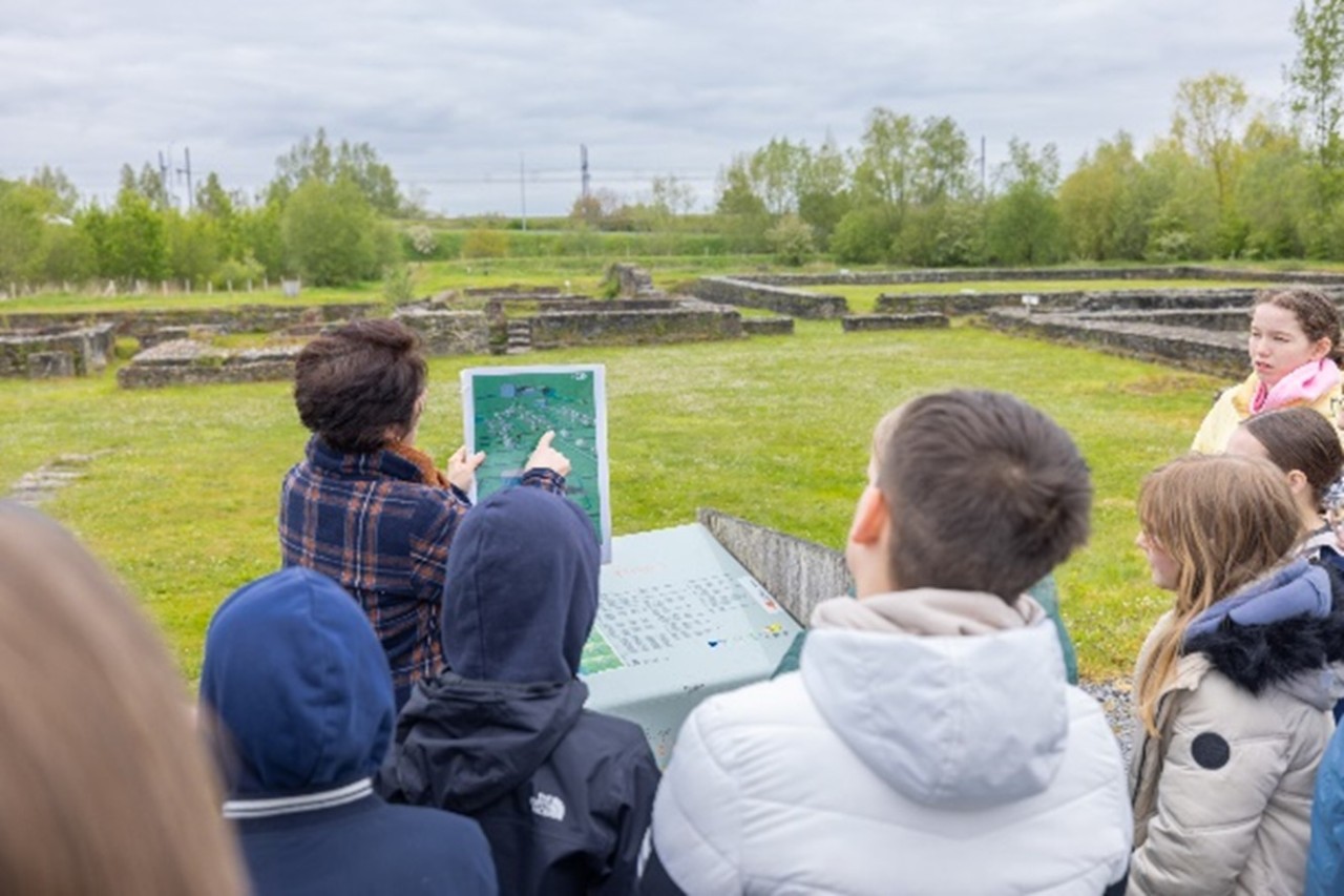 Gids met klas in Archeopark in Ename