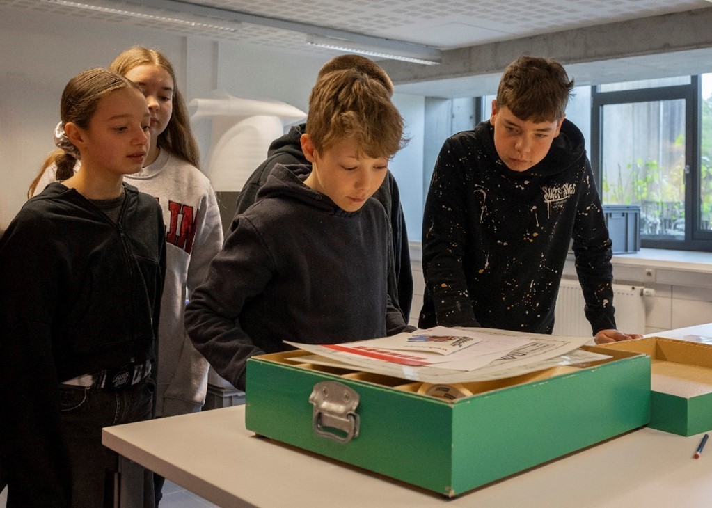 Kinderen kijken in een leskoffer