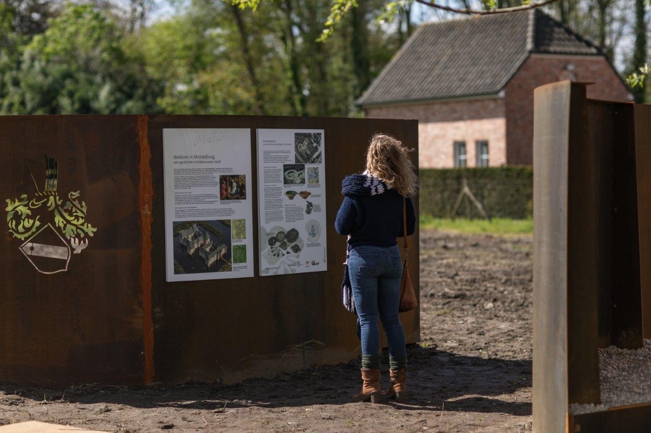 vrouw kijkt naar infobord erfgoedsite Middelburg